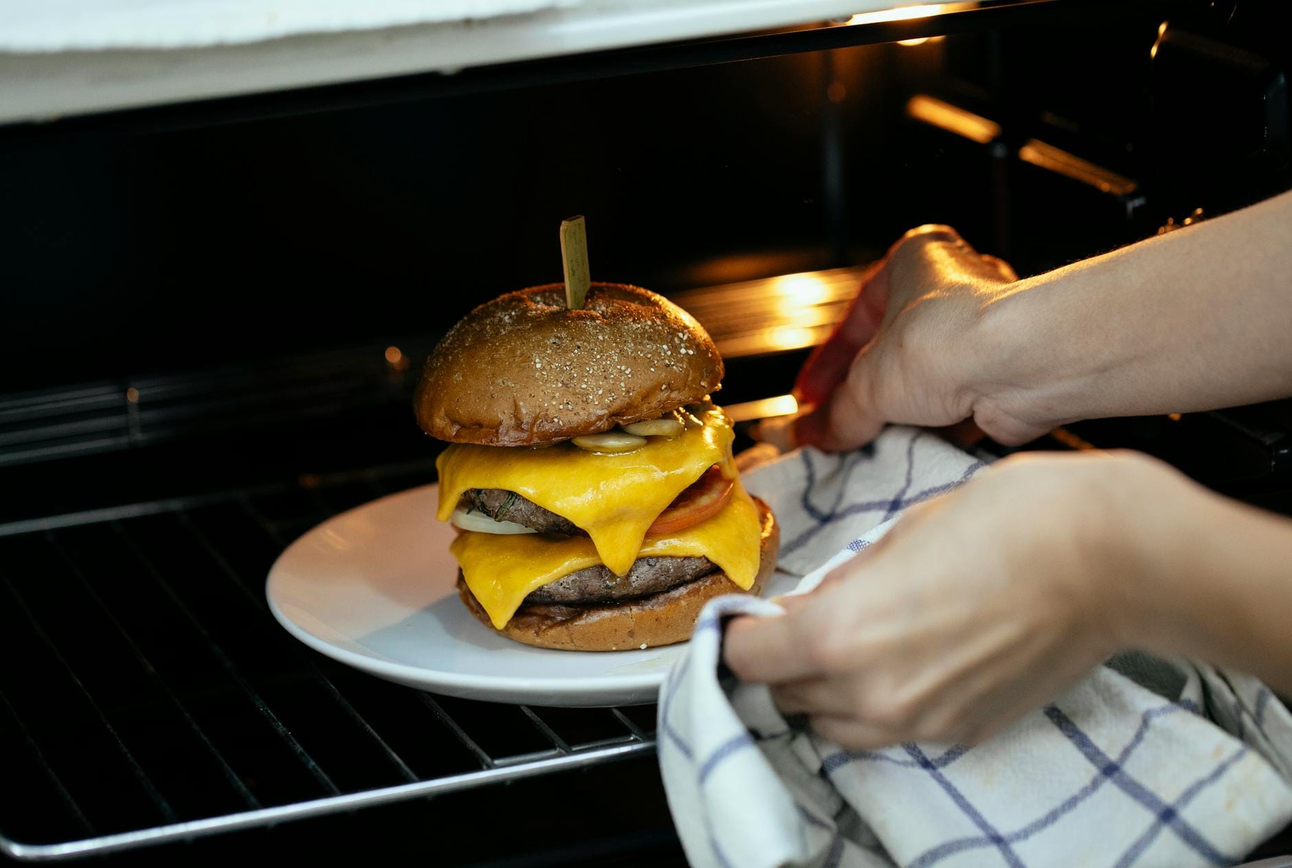 Wyjmowanie z piekarnika talerza z gorącą kanapką na kolację