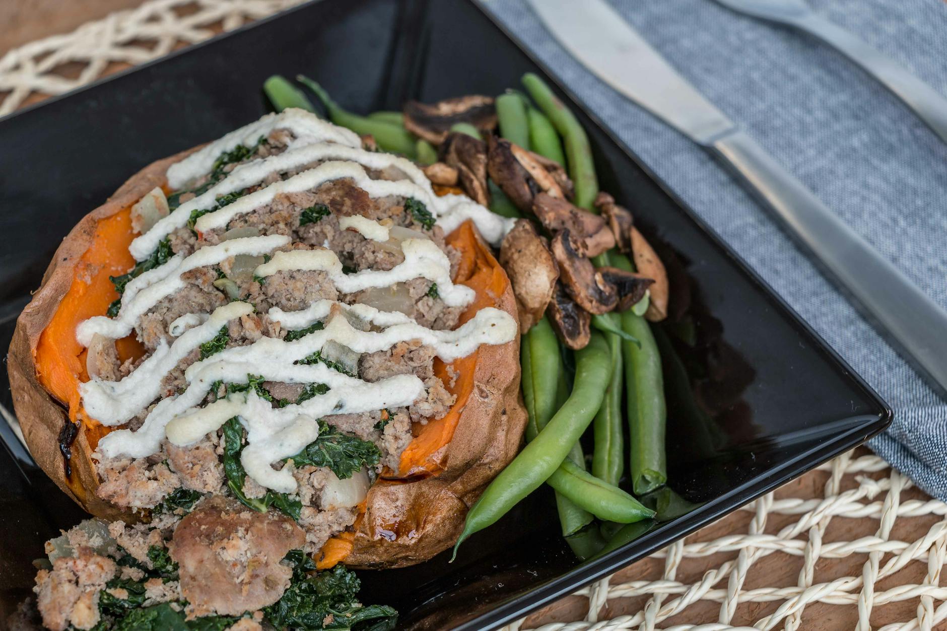 Faszerowany batat z pieczarkami i zieloną fasolką na talerzu