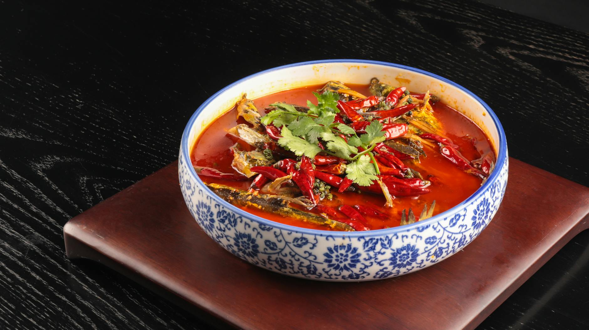 Miska pikantnej zupy pomidorowej z ziołami i papryką na drewnianej desce