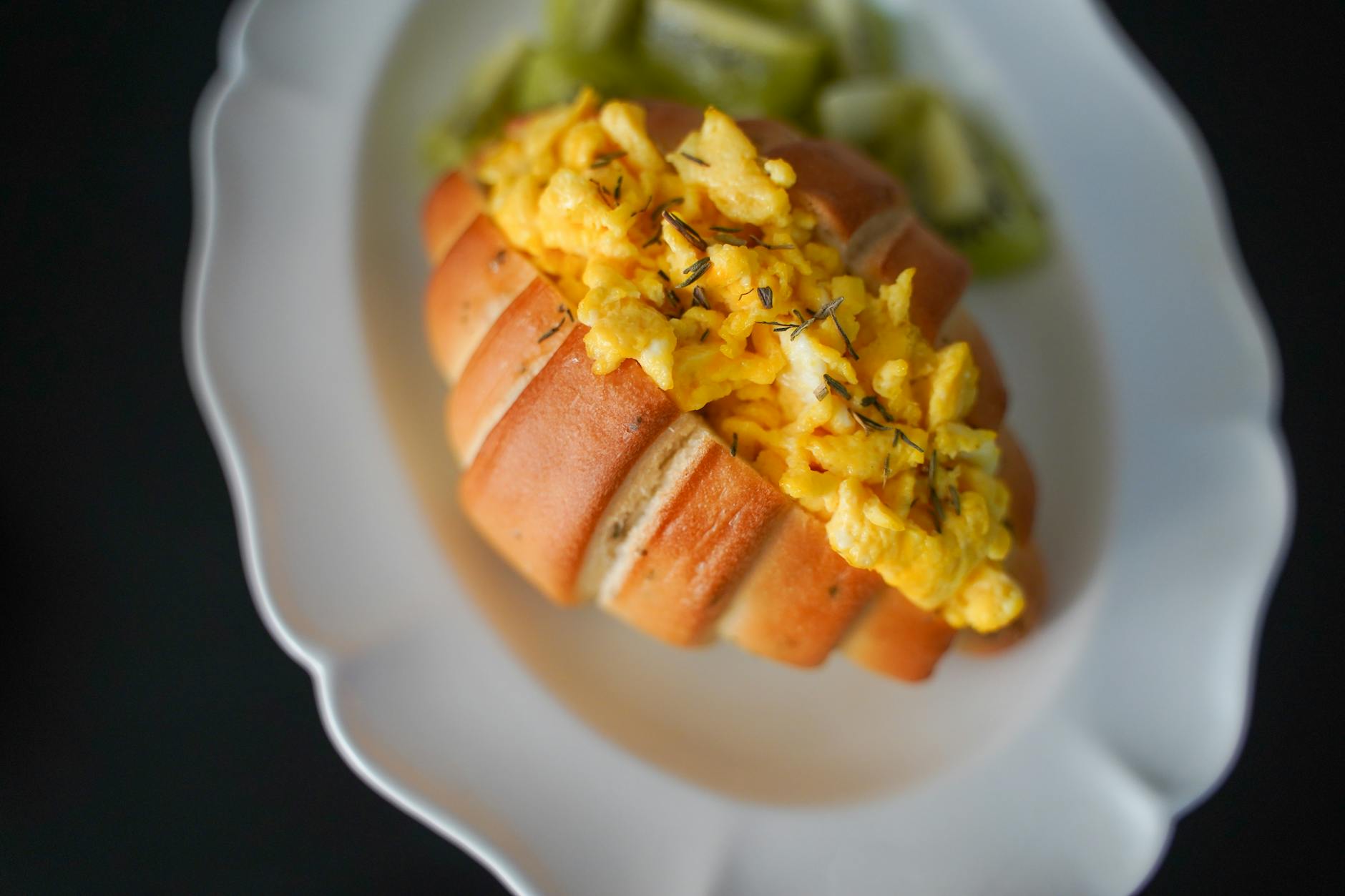 Kanapka z jajecznicą na talerzu jako propozycja śniadania