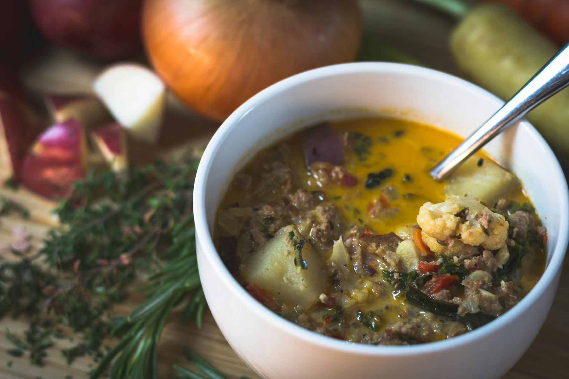 Miska domowej zupy warzywnej podana na biały talerz