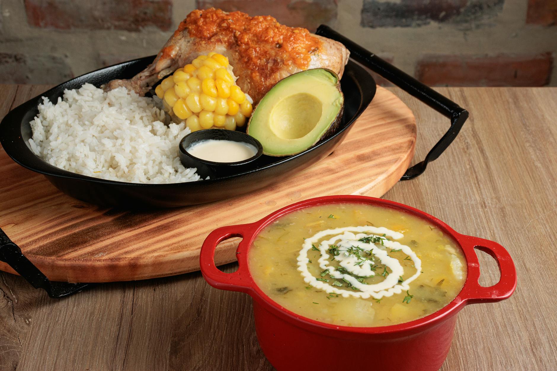 Talerz z kolumbijską zupą ajiaco i kawałkami kurczaka z dodatkami