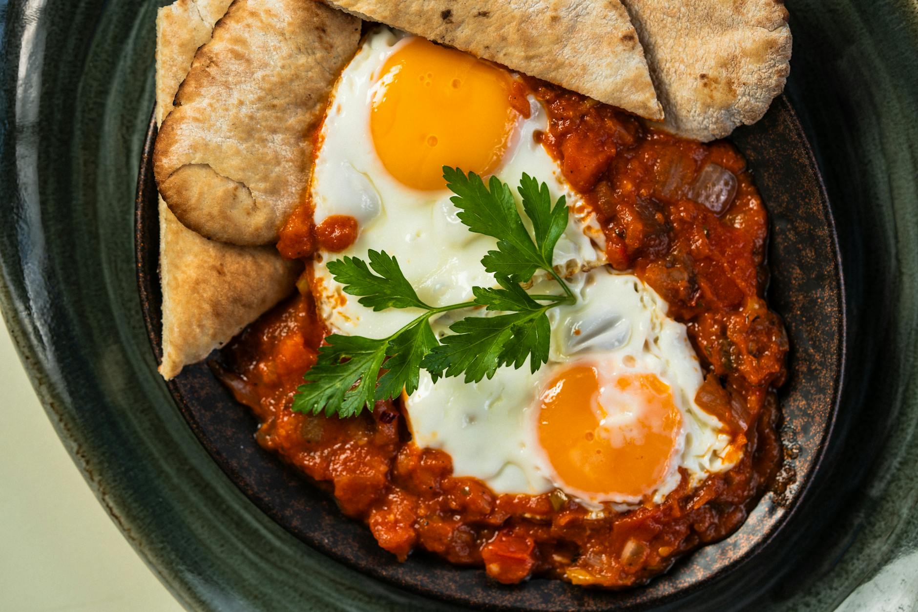 Patelnia z jajkami w sosie pomidorowym shakshuka z natką i pieczywem