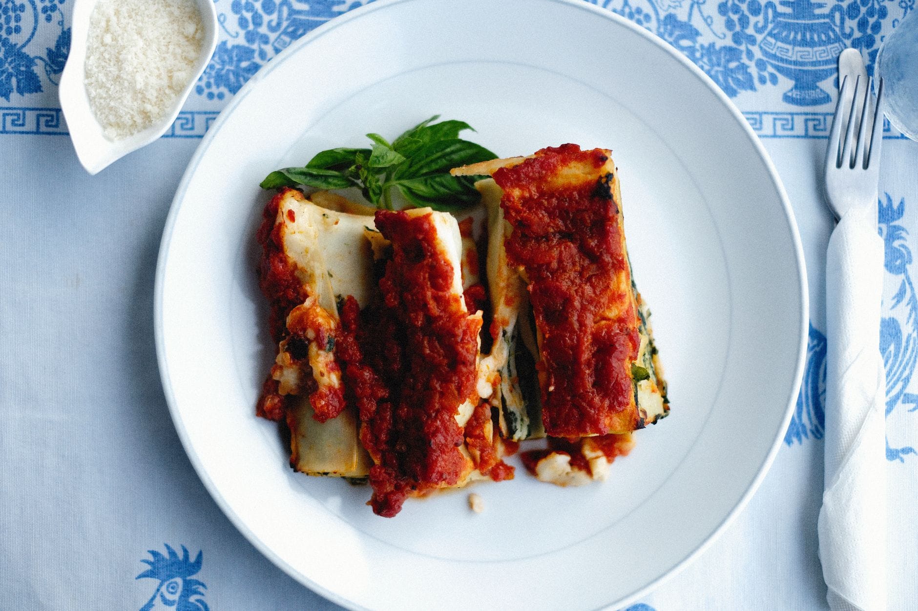 Lasagne z sosem pomidorowym i bazylią na talerzu, widok z góry
