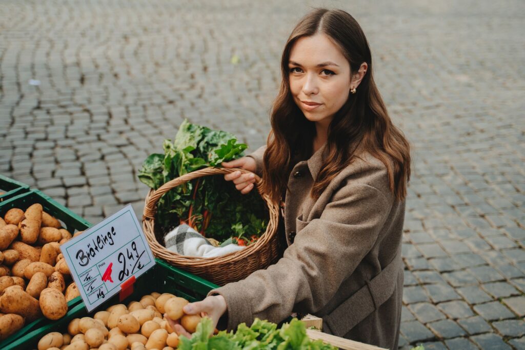 Kobieta kupuje świeże warzywa na targu